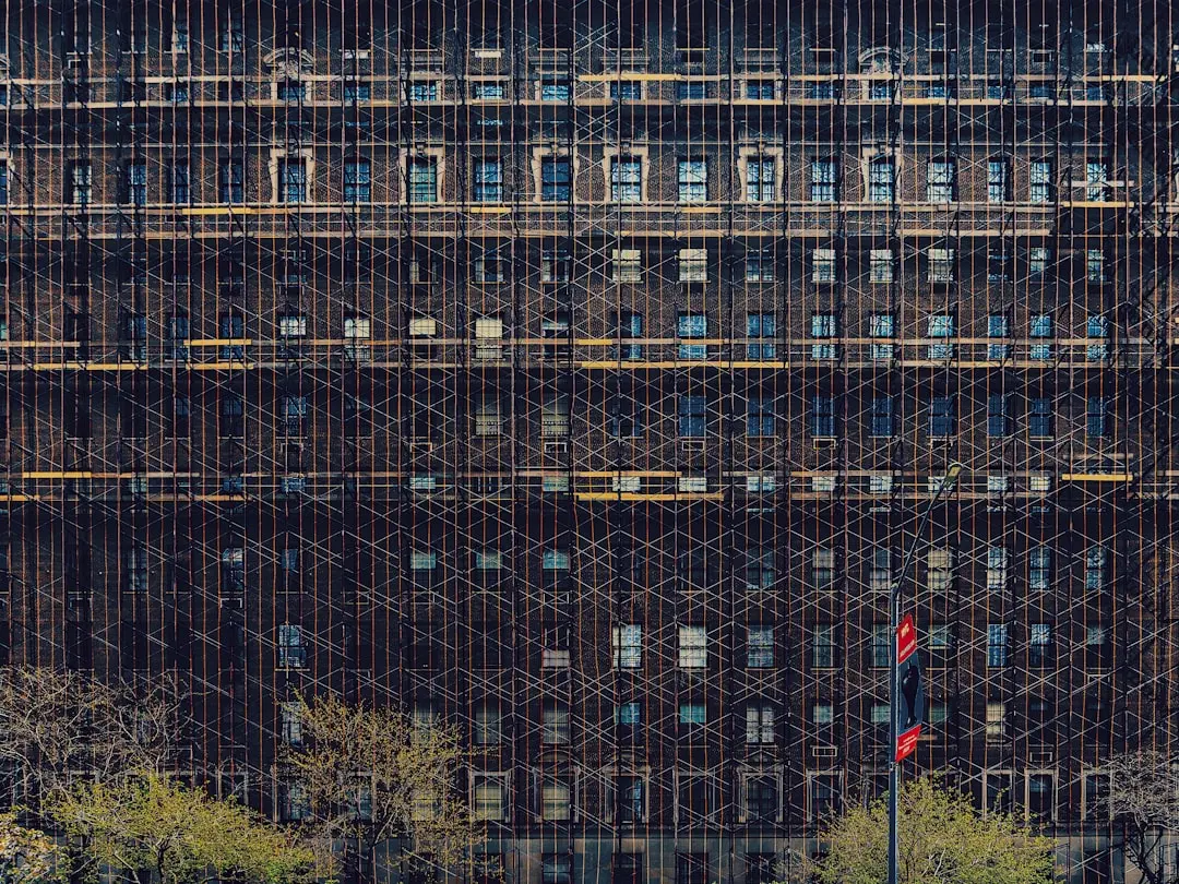 person in red jacket standing in front of building during daytime